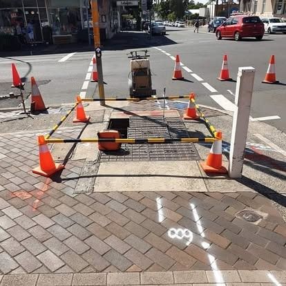 A sidewalk is marked with cones and lines — Dowds Pipe and Cable Locating in Farmborough Heights, NSW