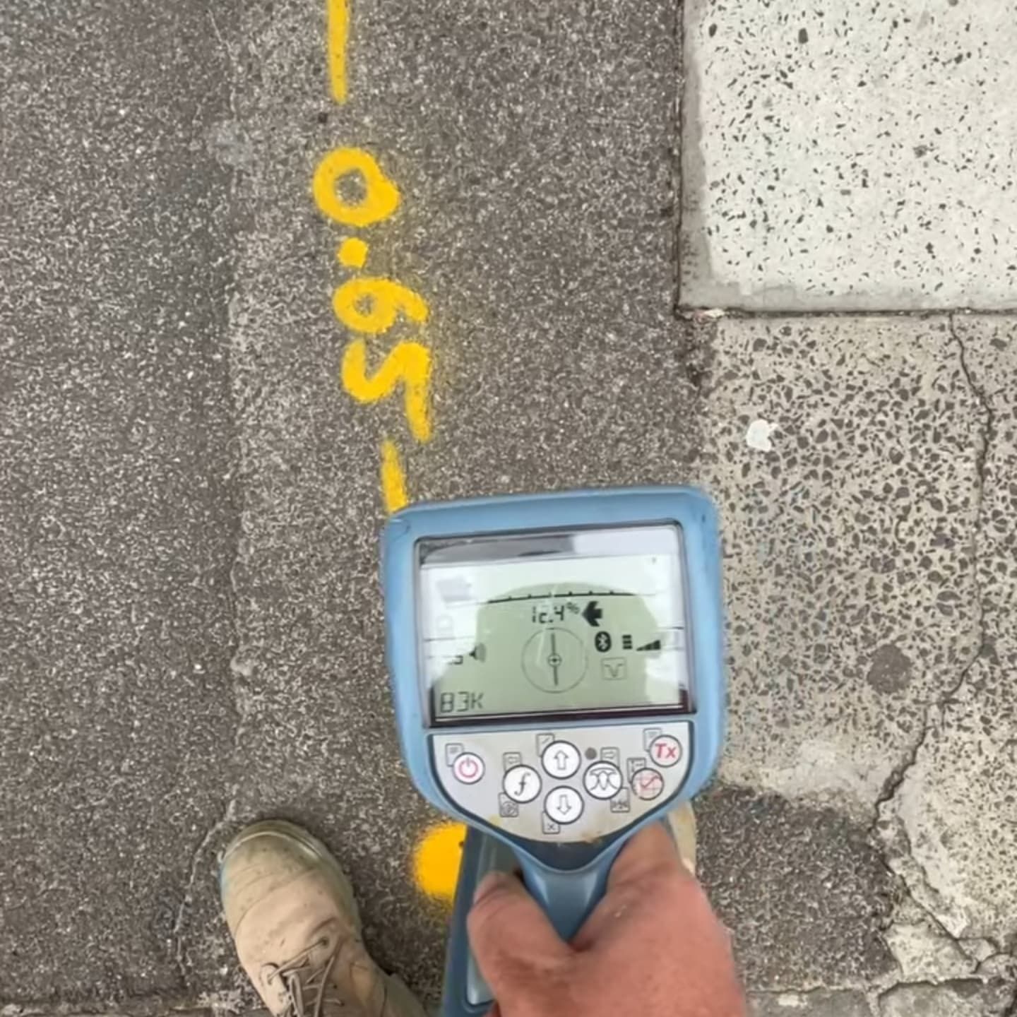 Someone is pointing a detection tool at the concrete — Dowds Pipe and Cable Locating in Farmborough Heights, NSW