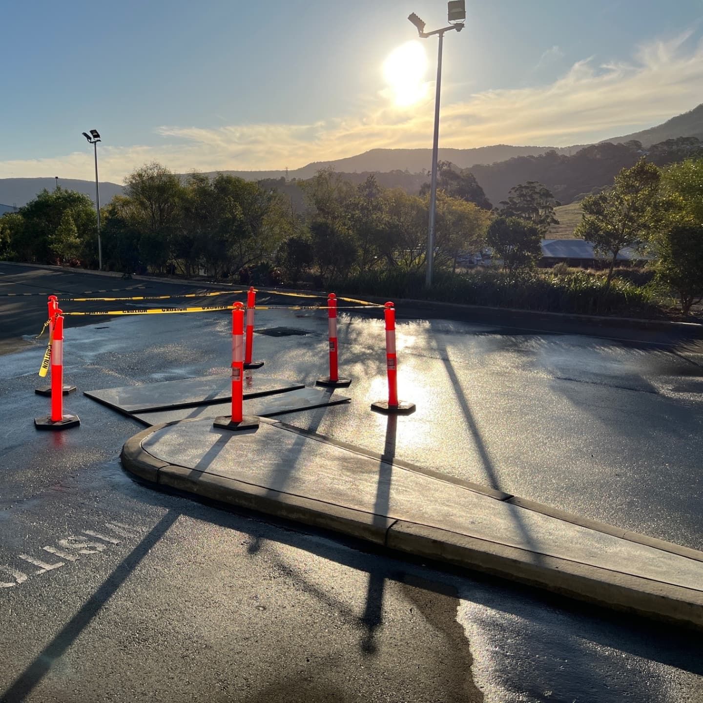 Sun shining over a work area with orange marker posts — Dowds Pipe and Cable Locating in Farmborough Heights, NSW