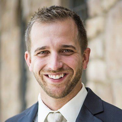 A man in a suit and tie is smiling for the camera.