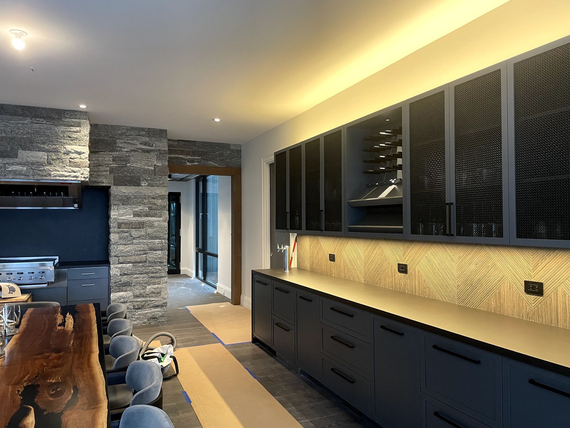 A kitchen with black cabinets and a wooden table