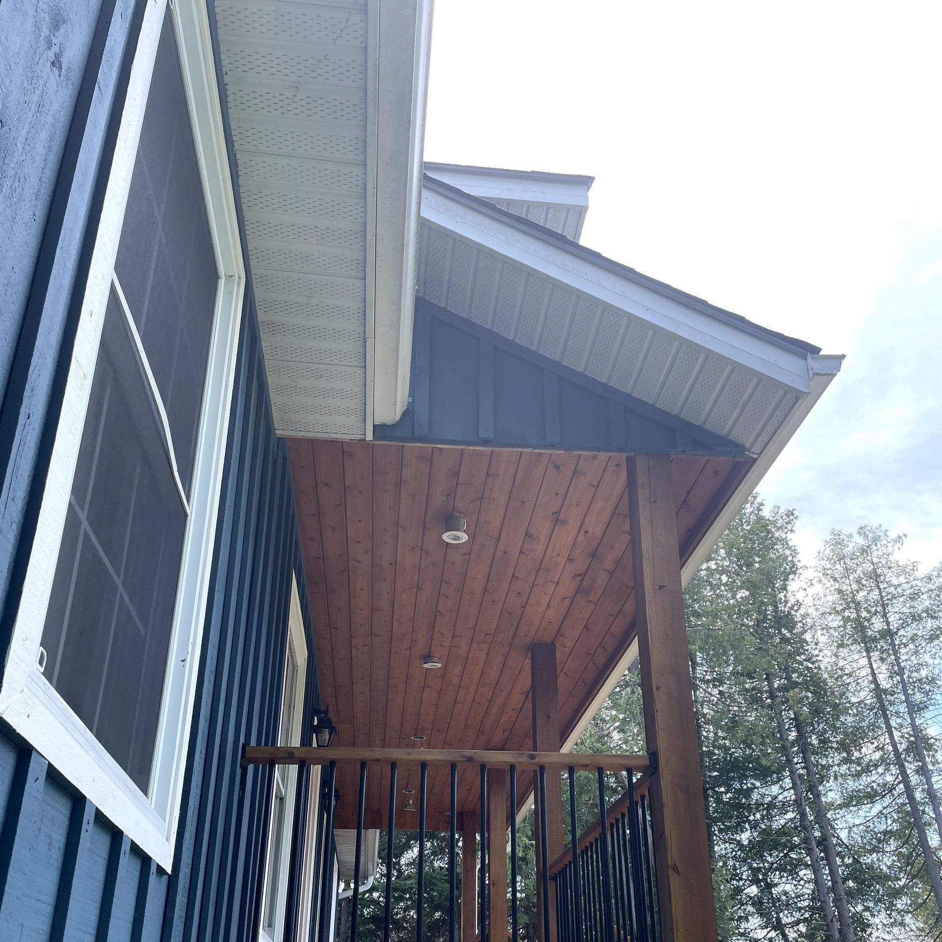 A blue house with a wooden deck and stairs.