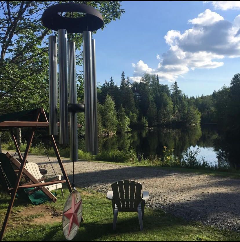 A chair sits in front of a large wind chime