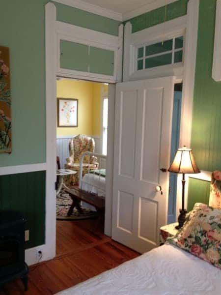 A bedroom with green walls and a white door