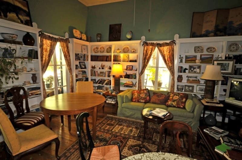 A living room with a green couch a table and chairs