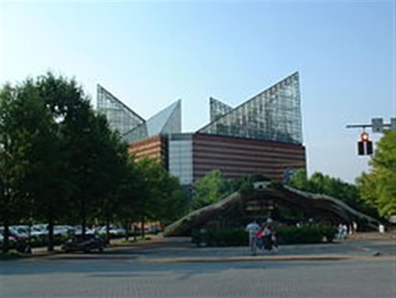 A group of people are walking in front of a large building.