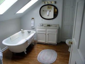 A bathroom with a bathtub , sink , toilet and mirror.