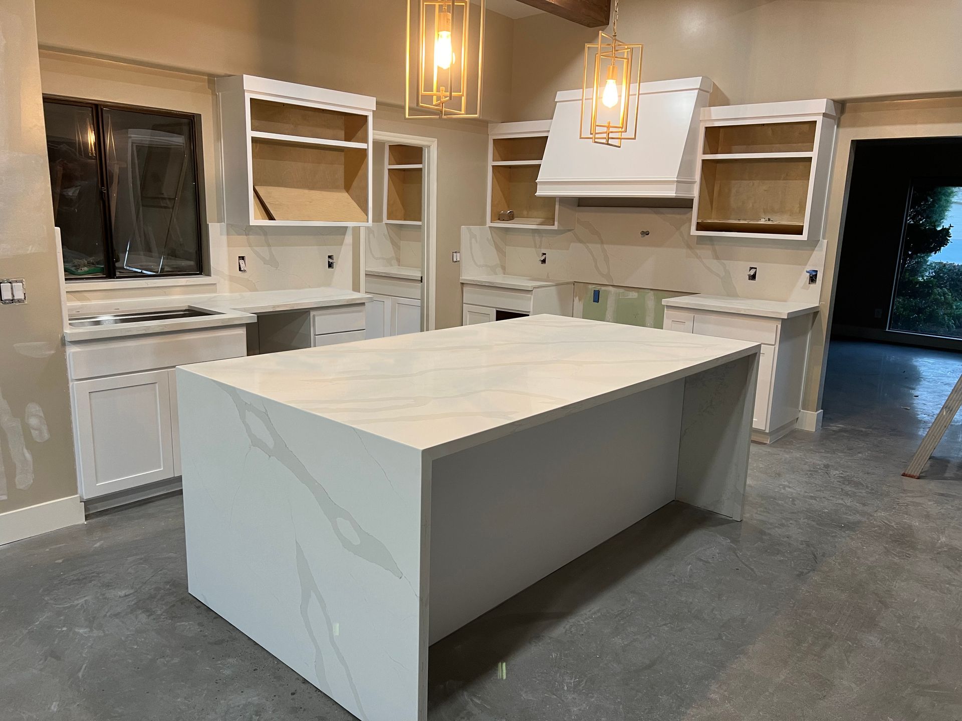 A kitchen under construction with a large island in the middle.
