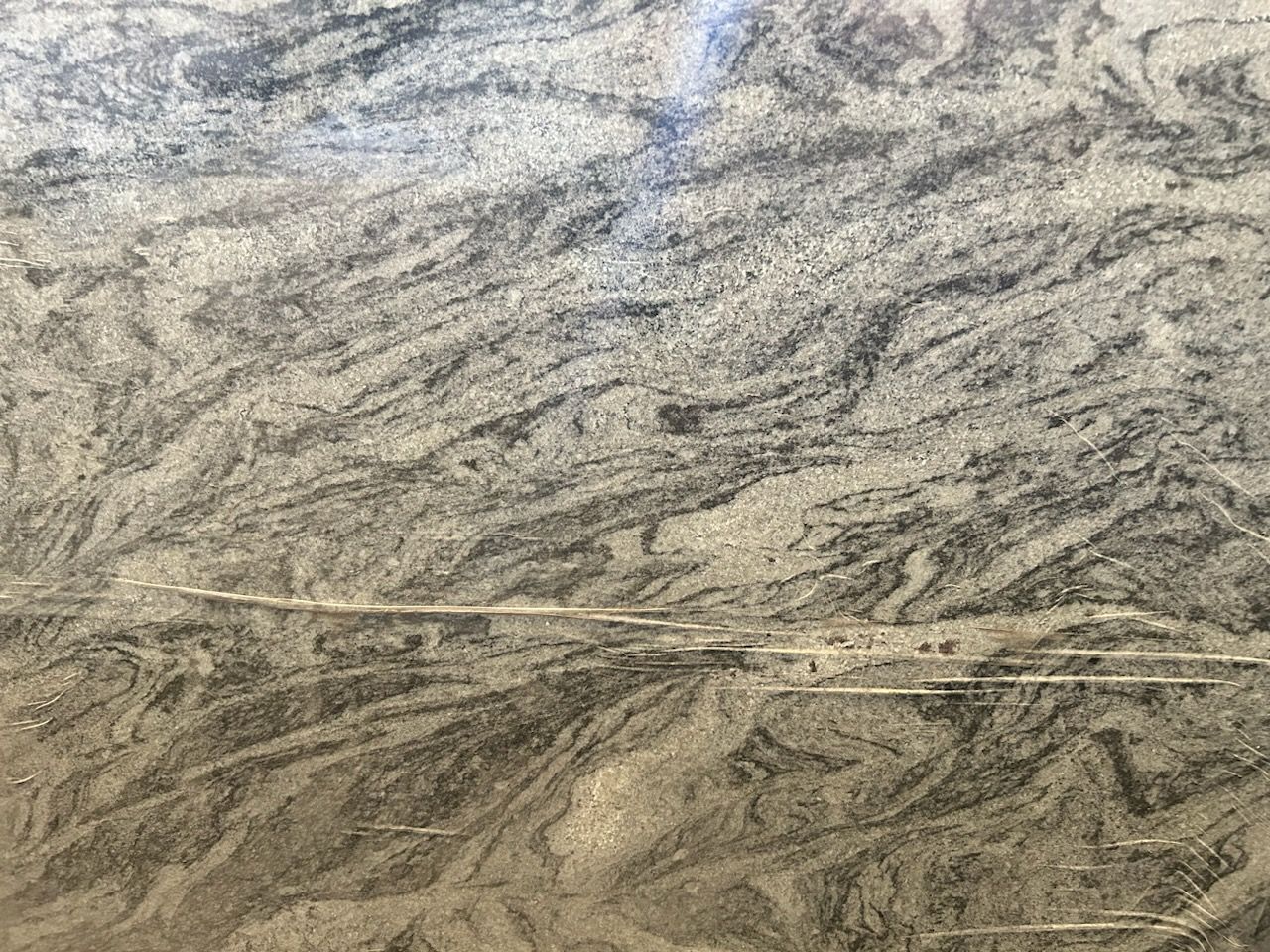 A close up of a granite counter top with a marble texture.