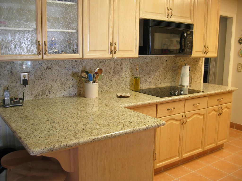A kitchen with granite counter tops and wooden cabinets