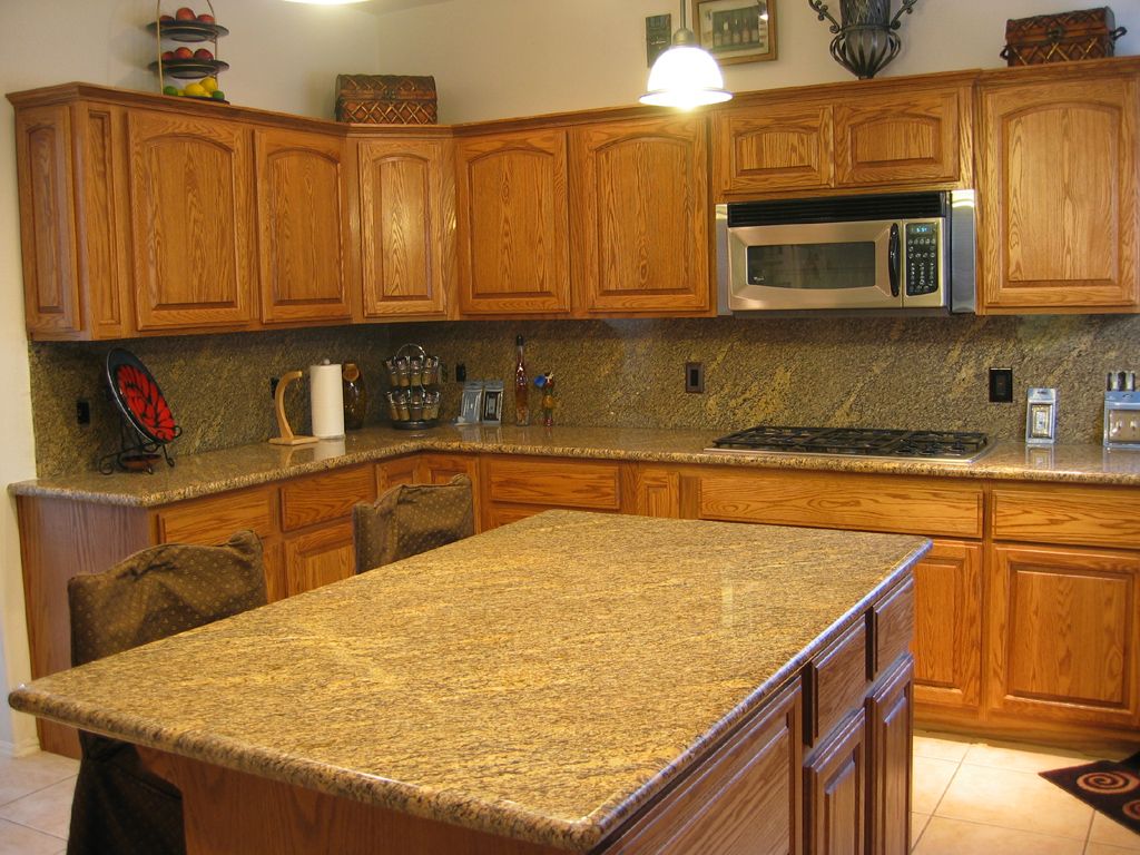 A kitchen with wooden cabinets and granite counter tops