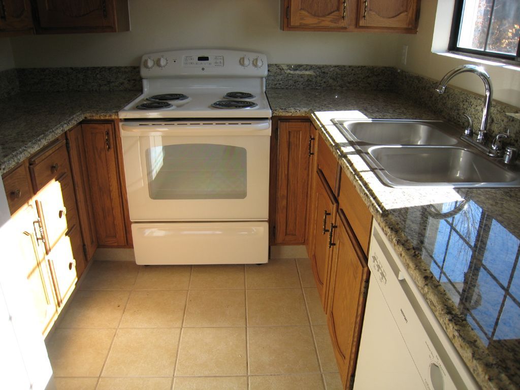 A kitchen with a stove top oven and a sink