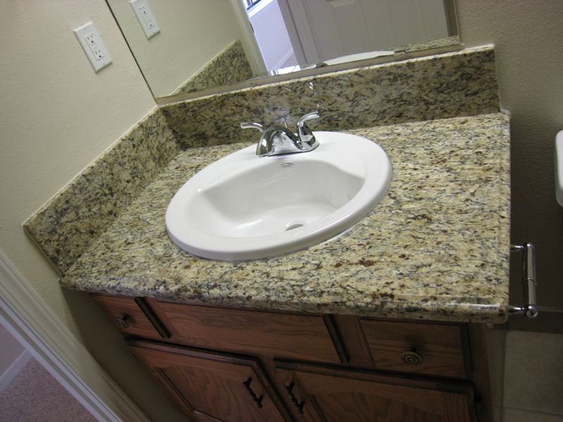 A bathroom sink with a granite counter top