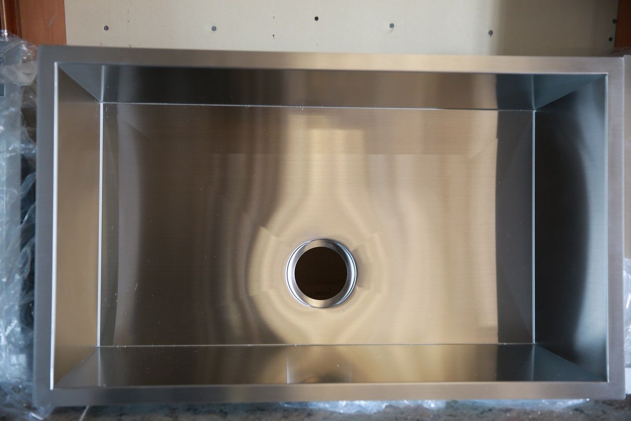 A stainless steel kitchen sink with a hole in the middle.