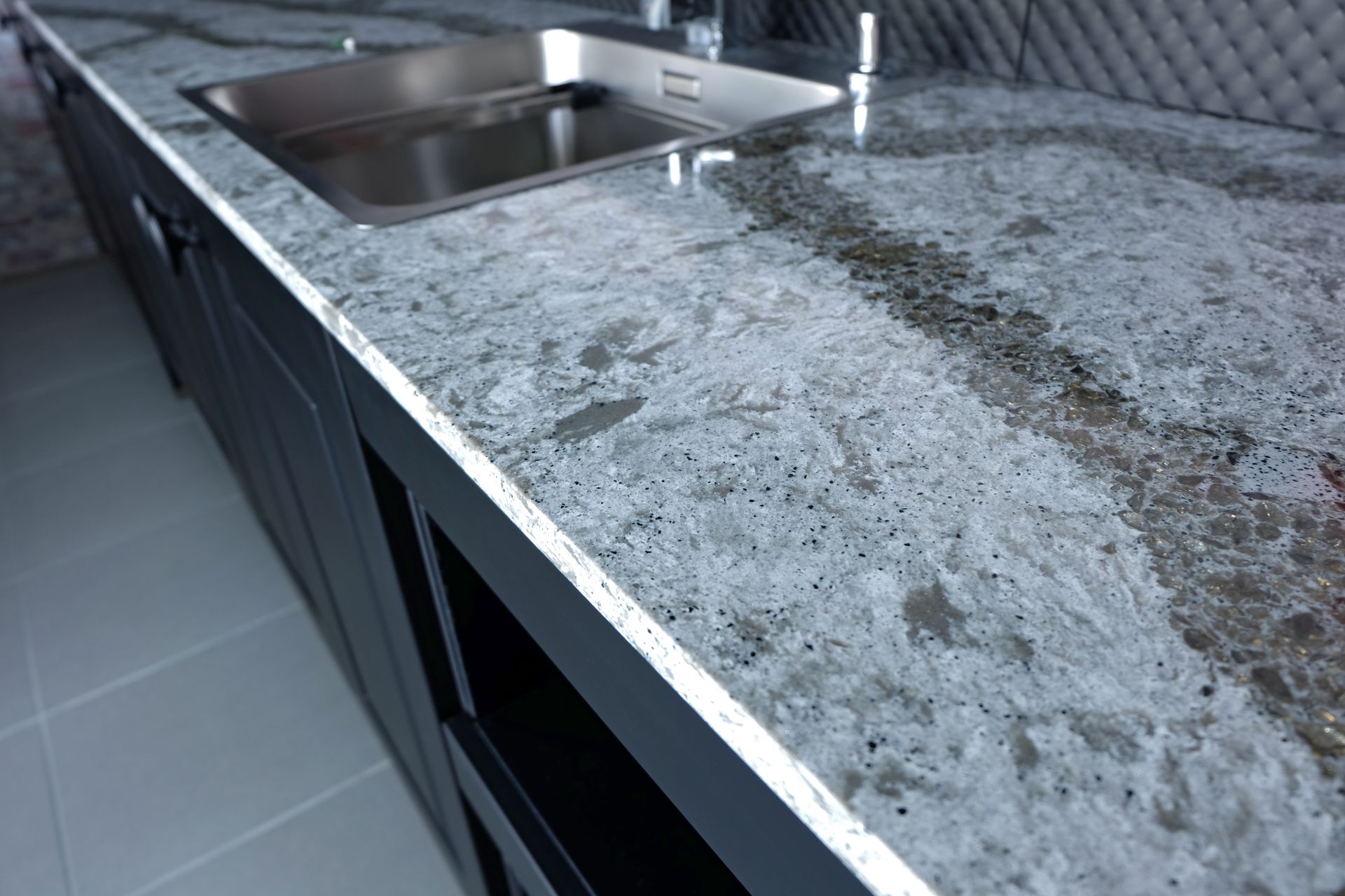 Granite kitchen countertop with stainless steel sink and modern cabinetry