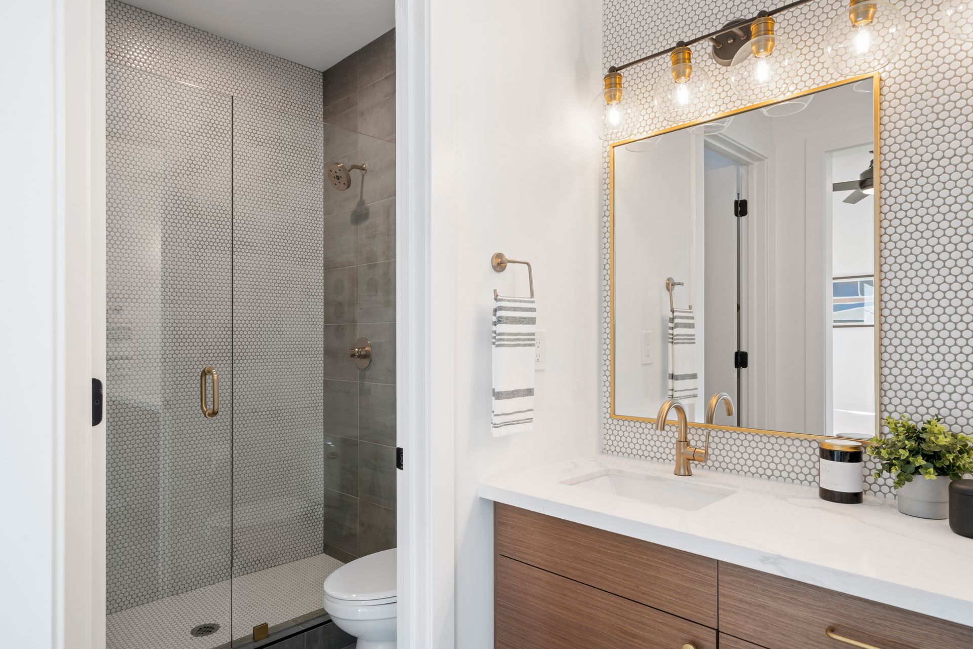 A bathroom with a toilet , sink , mirror and shower.