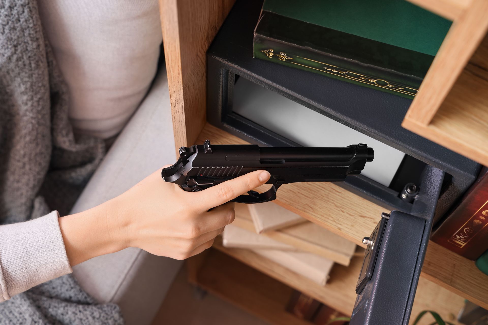 Woman placing gun in gun safe in her home