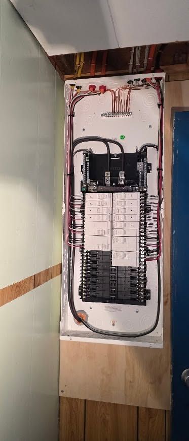 Open electrical breaker panel with exposed wiring in a hallway