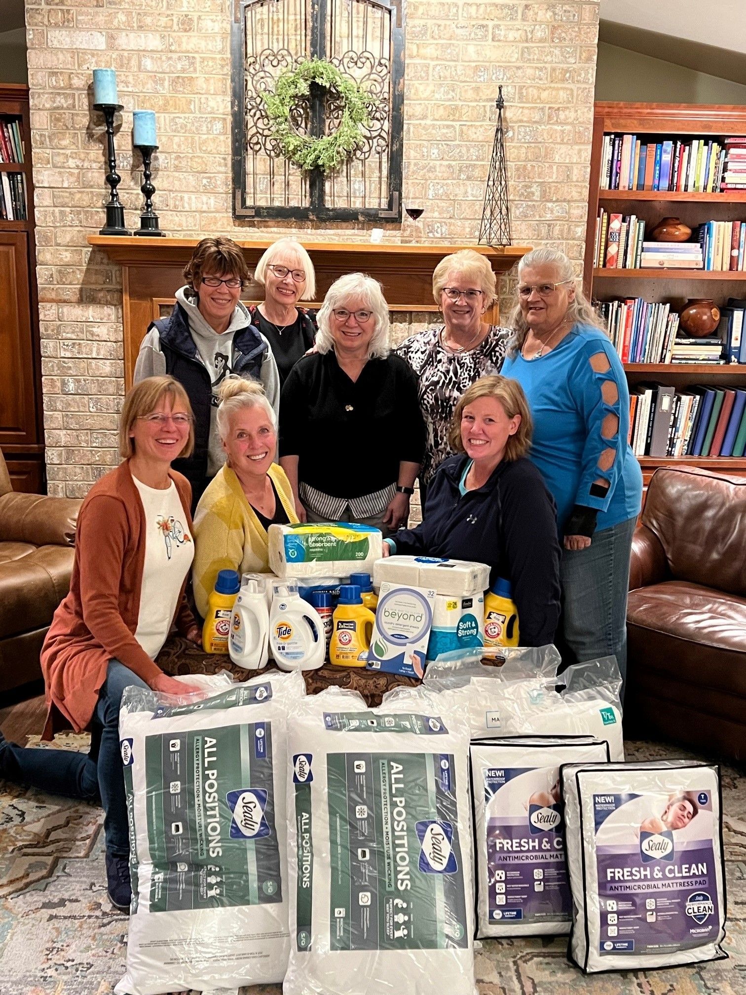 A group of women are posing for a picture in a living room.