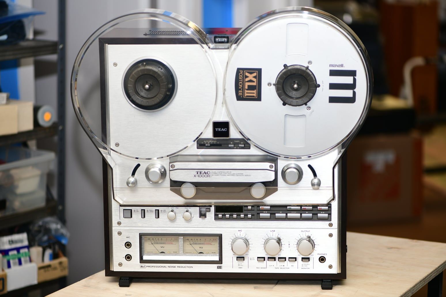 Vintage silver reel-to-reel tape recorder on a table, front view