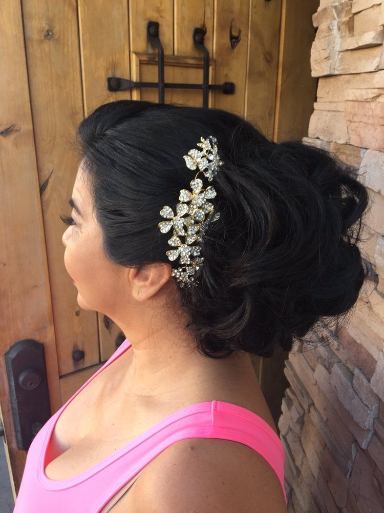 The woman is wearing a pink tank top and has a flower in her hair.