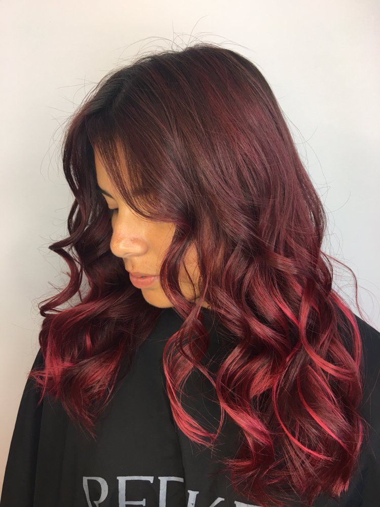 A woman with long red hair is wearing a black shirt.