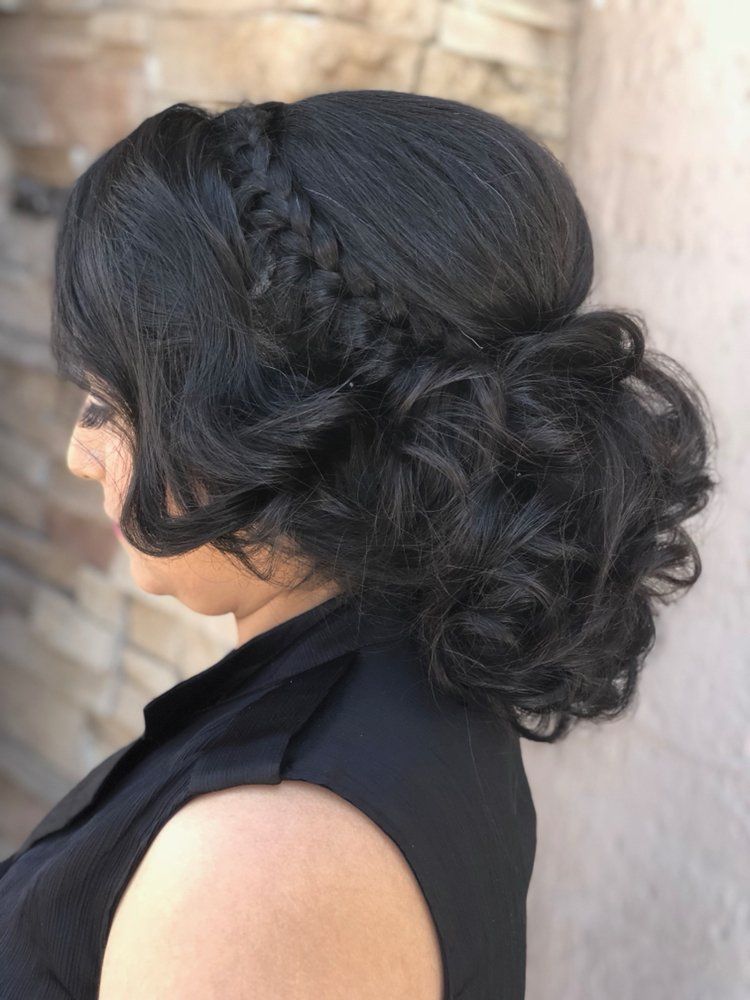 A woman is wearing her hair in a bun with a braid.