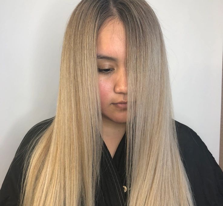A woman with long blonde hair is wearing a black shirt.