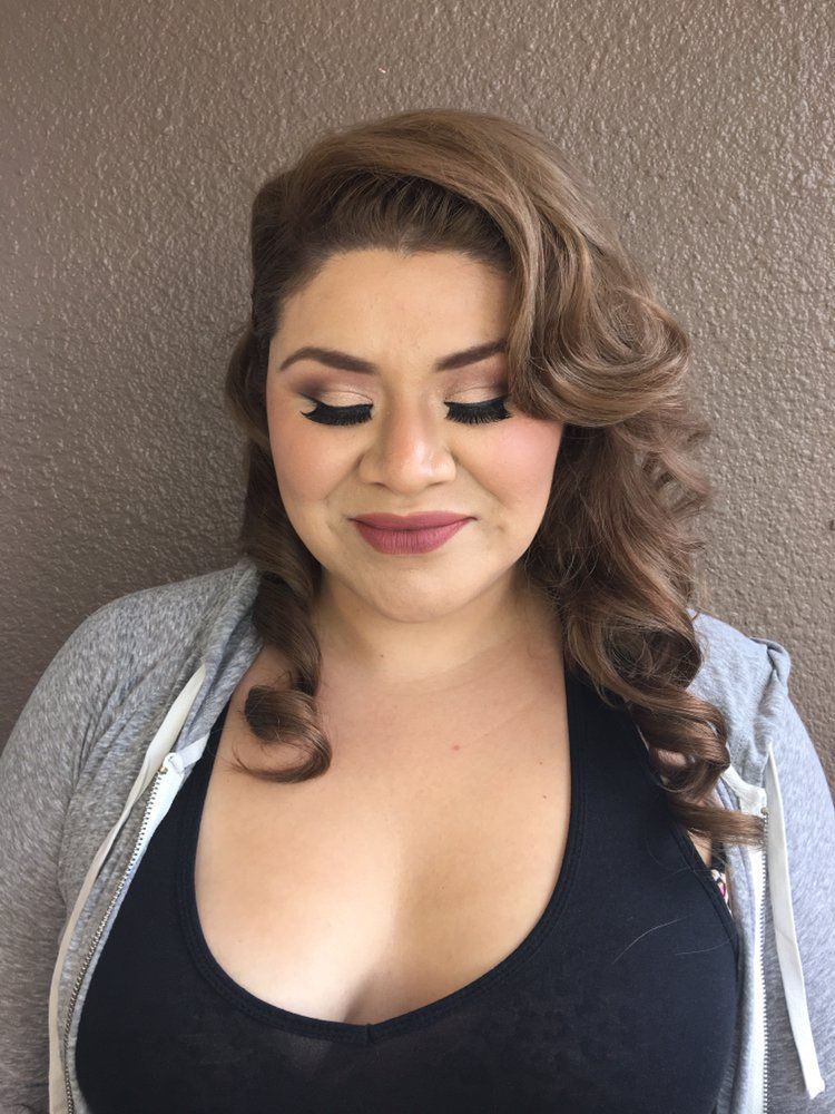 A woman is getting her makeup done by a makeup artist.