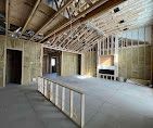 A room in a house under construction with a fireplace.