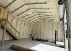 A large warehouse with a staircase leading up to the second floor.