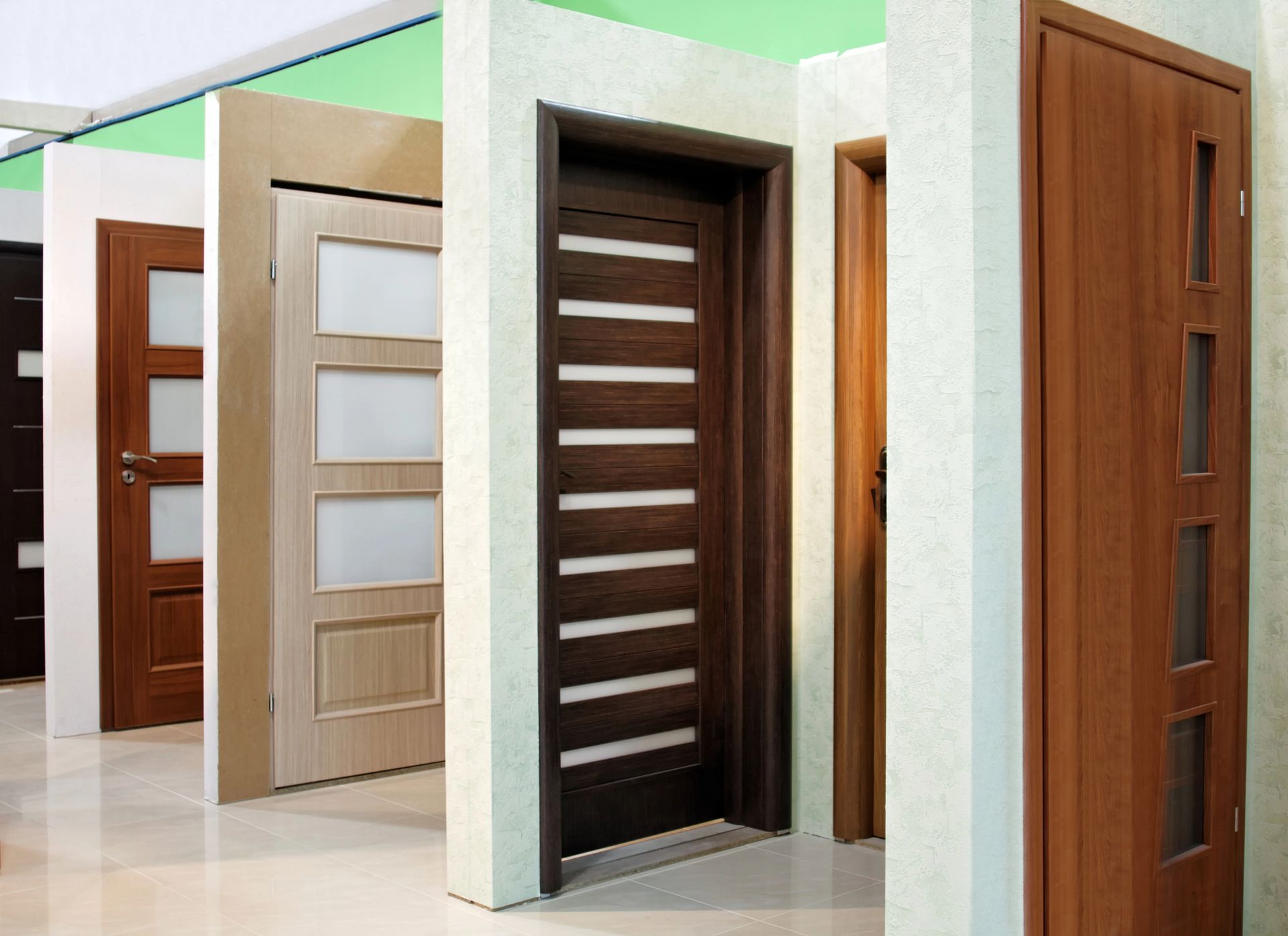 Diverse porte interne in esposizione, che presentano stili e finiture in legno diversi.