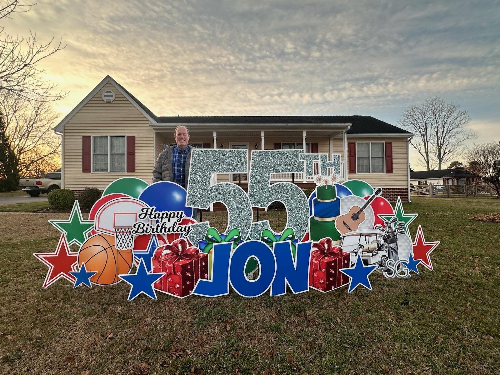 A birthday sign for jon is in front of a house.