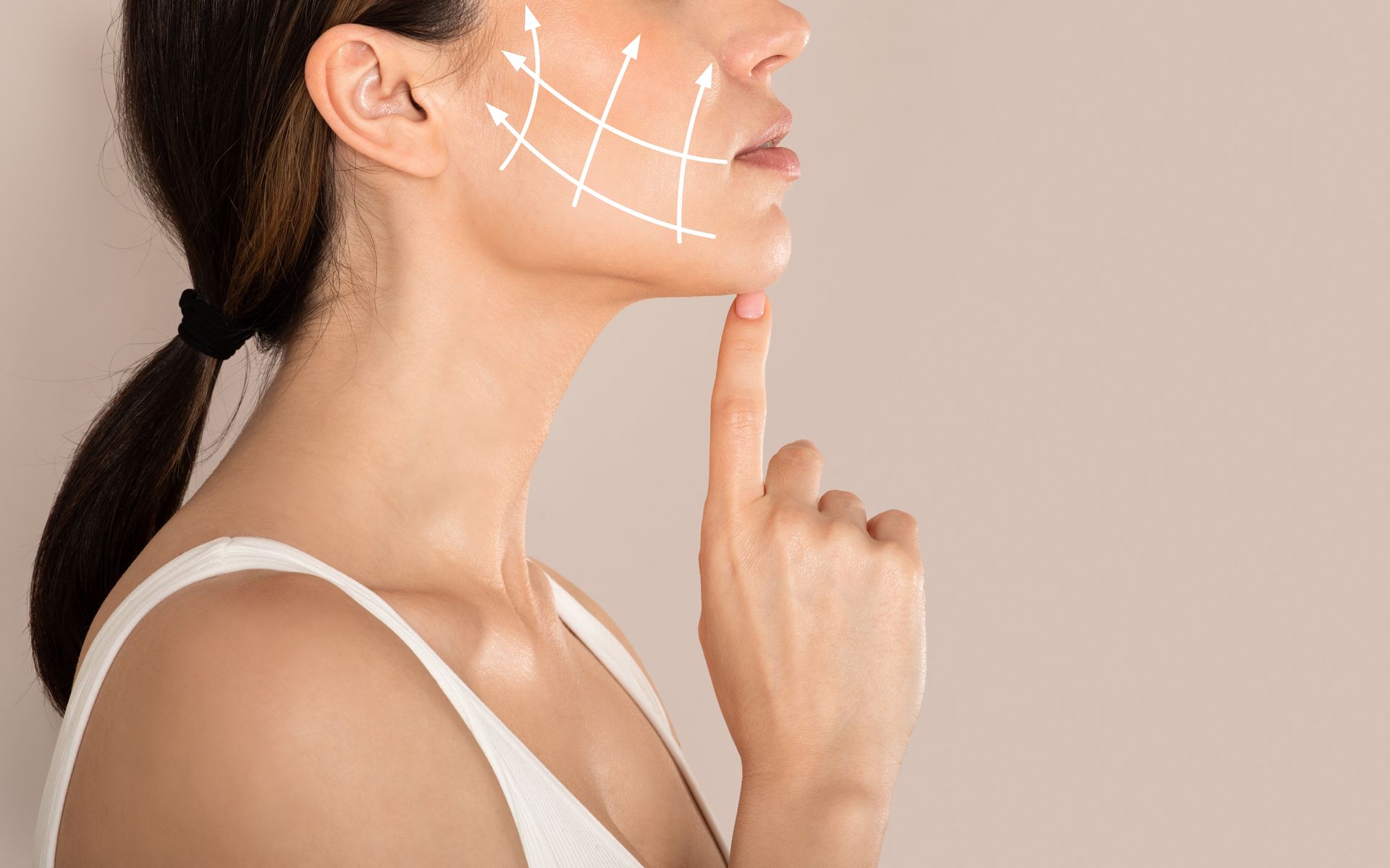 Profile of a woman touching her chin, with white guide lines marked on her face against a plain background