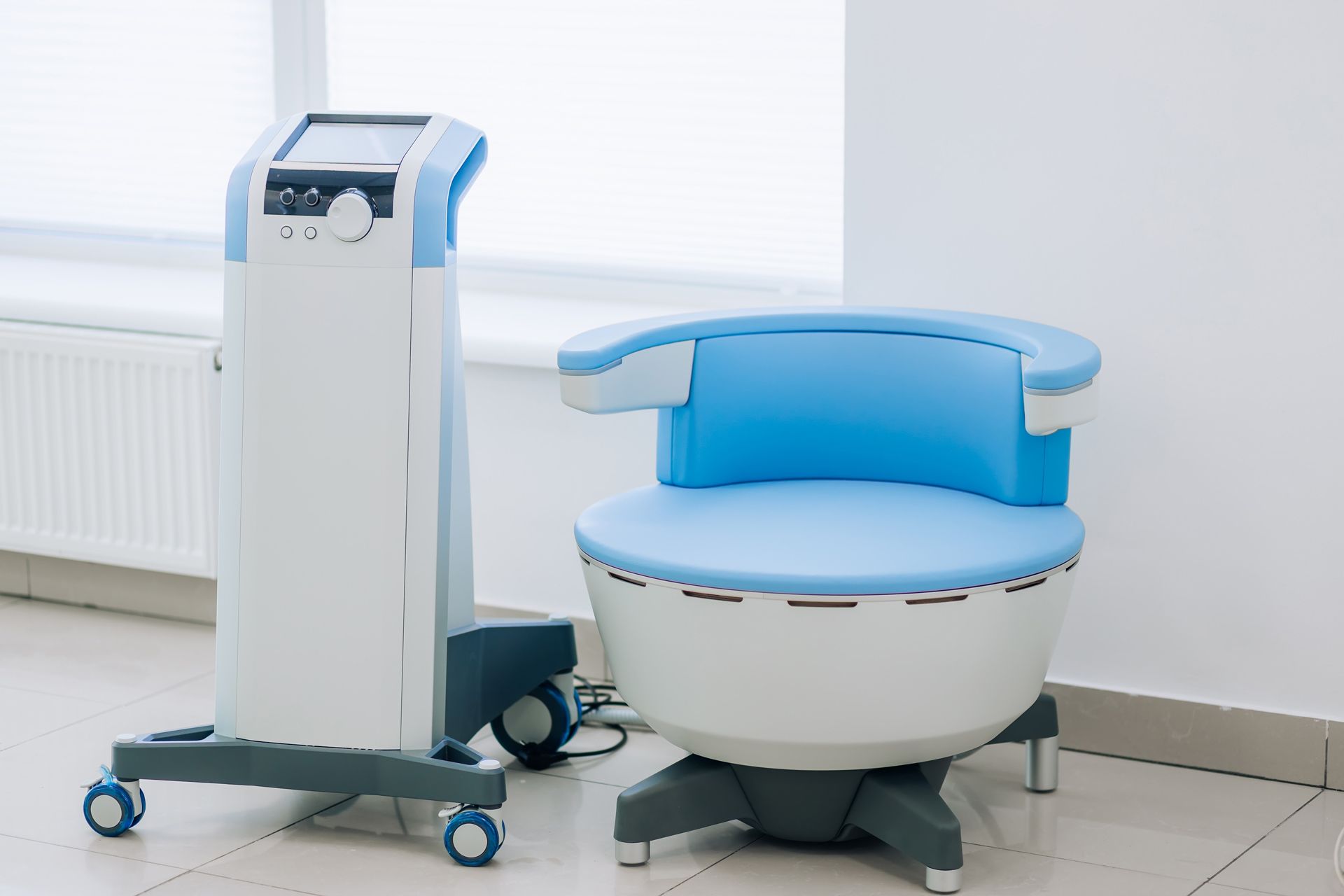 Blue medical device beside a matching chair in a clean clinic room