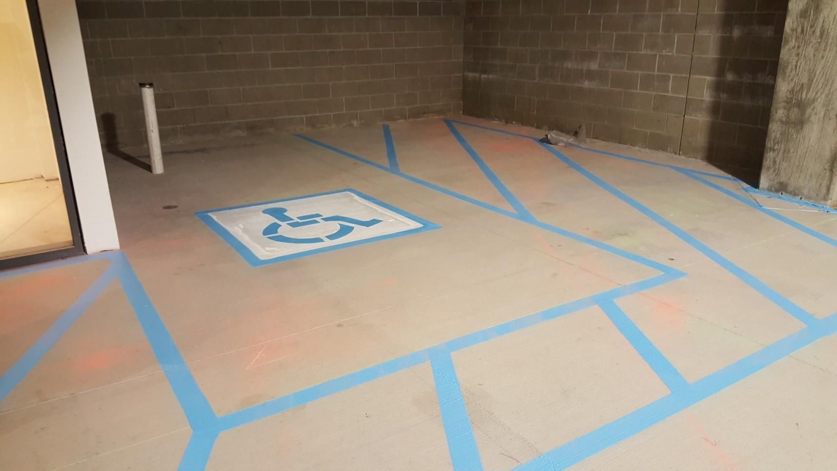 A handicapped parking spot is painted on the floor of a building.