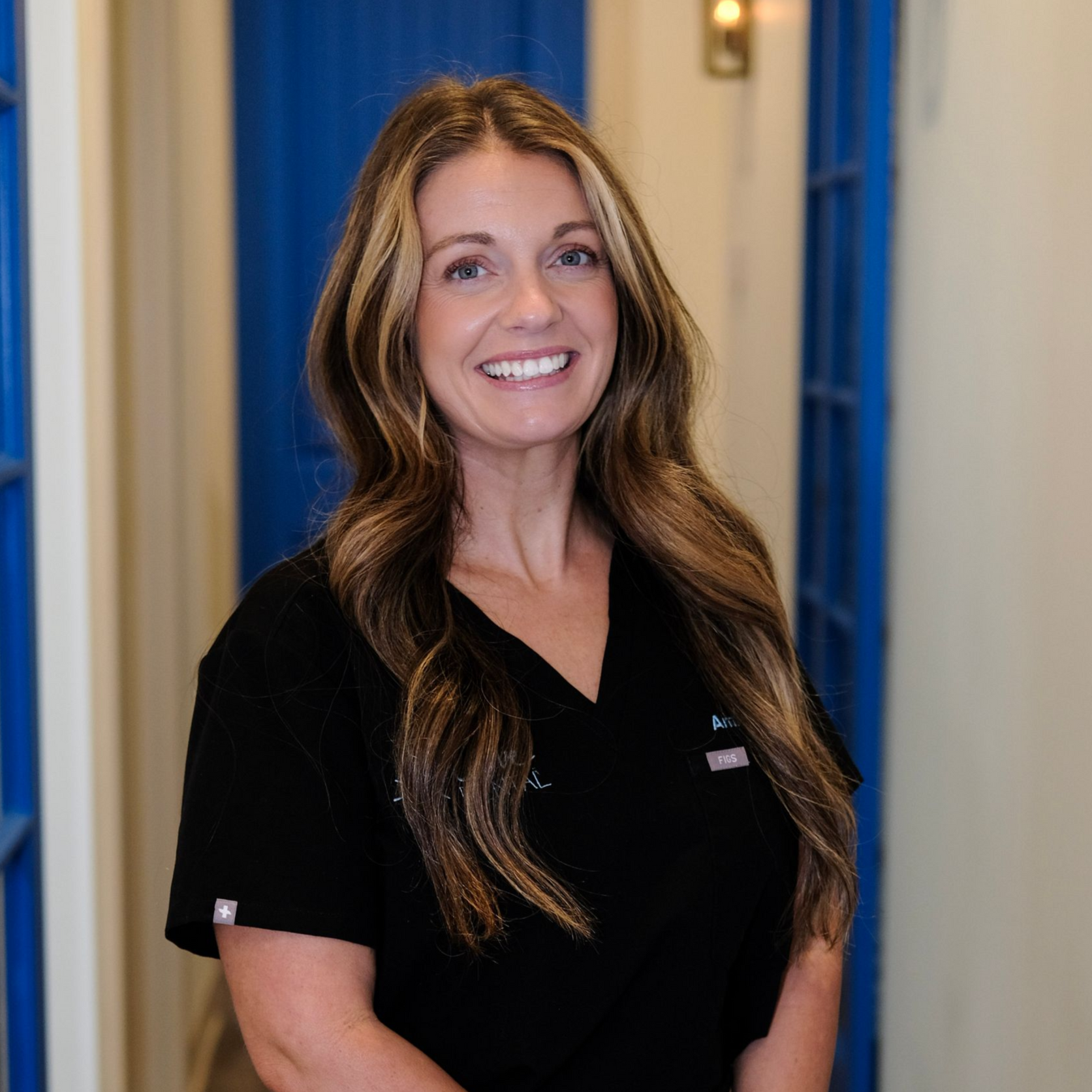 Smiling healthcare worker in black scrubs in a dental clinic