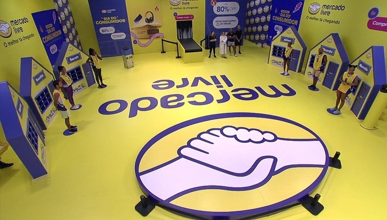 Um grupo de pessoas está em volta de um grande logotipo do mercado livre