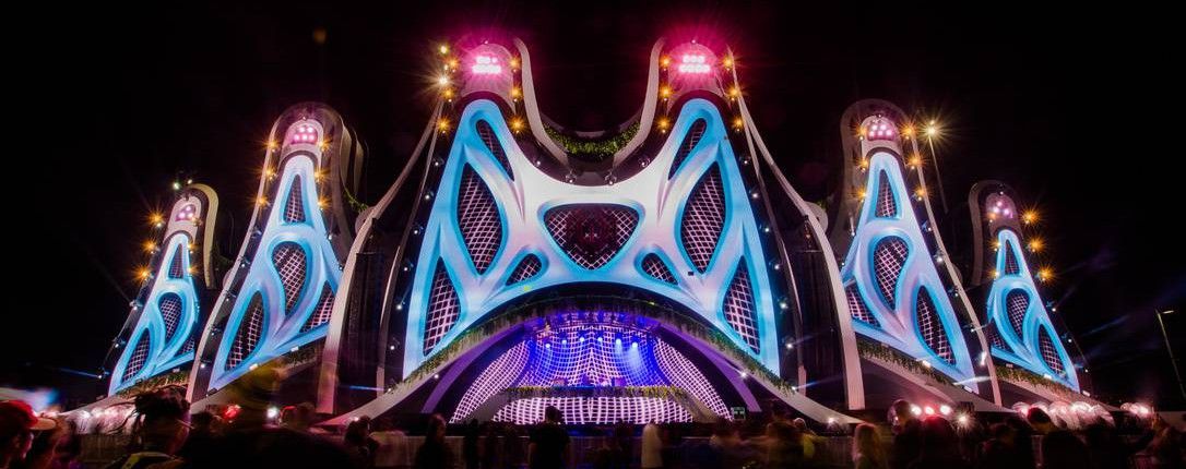 Uma multidão de pessoas está em frente ao palco de um show.