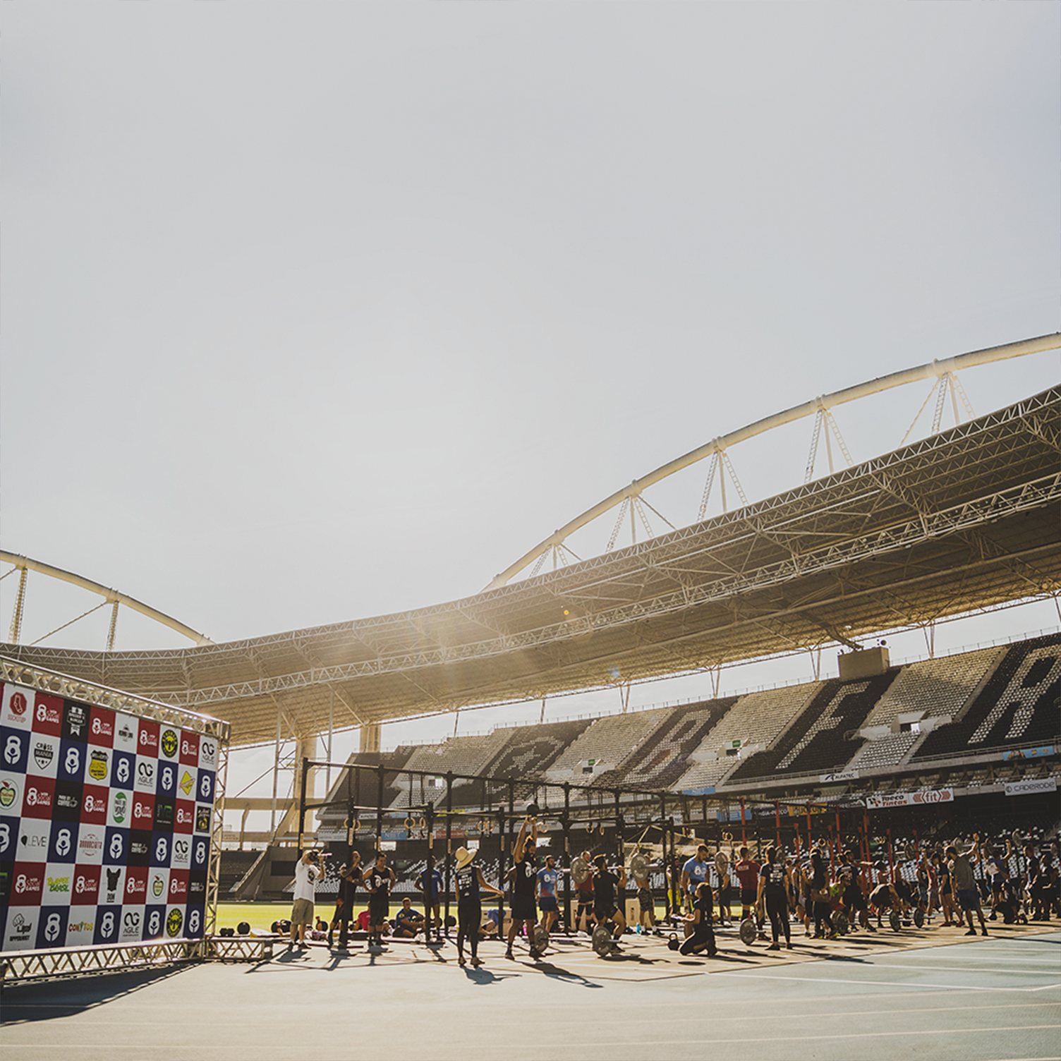 Um grupo de pessoas está em frente a um grande estádio.