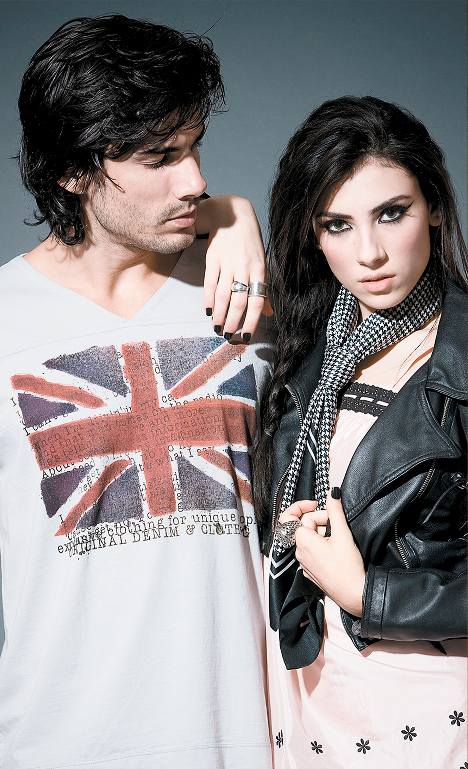 A man and a woman are posing for a picture . the man is wearing a british flag shirt.