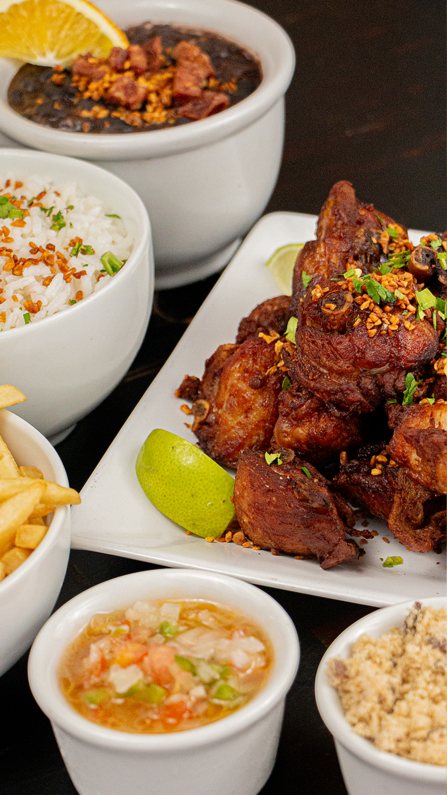 A table topped with plates of food and bowls of sauce.