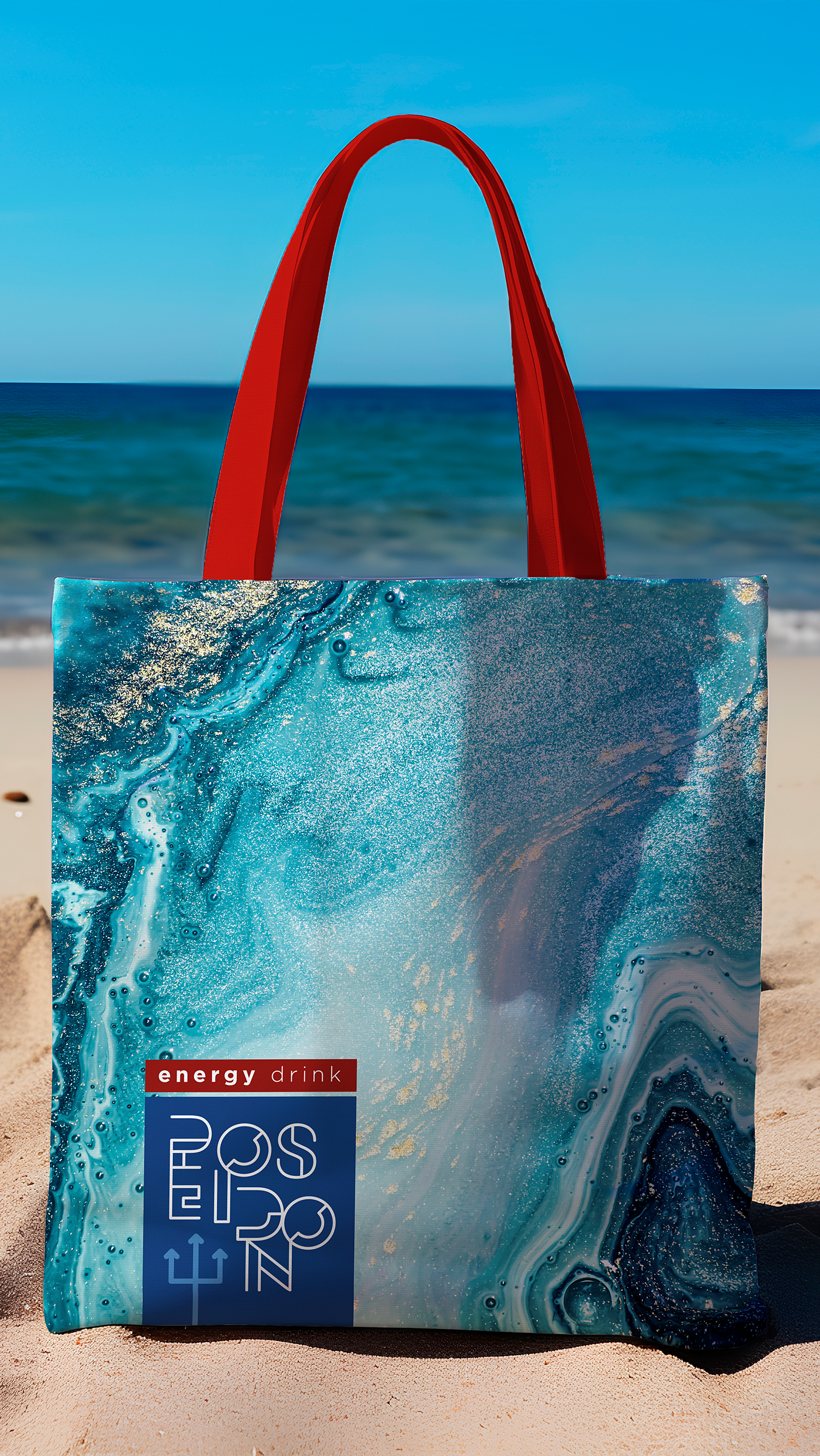 Poseidon Energy Drink A blue and white tote bag with a red handle is sitting on a beach.