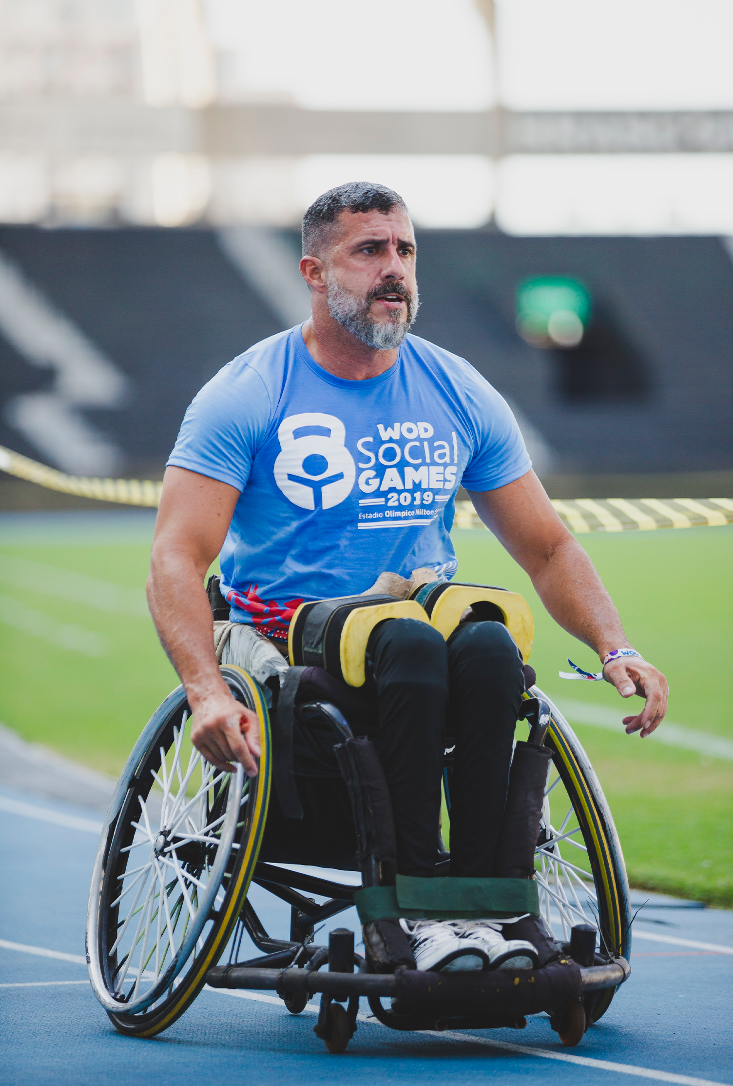 Um homem está sentado em uma cadeira de rodas em uma pista.