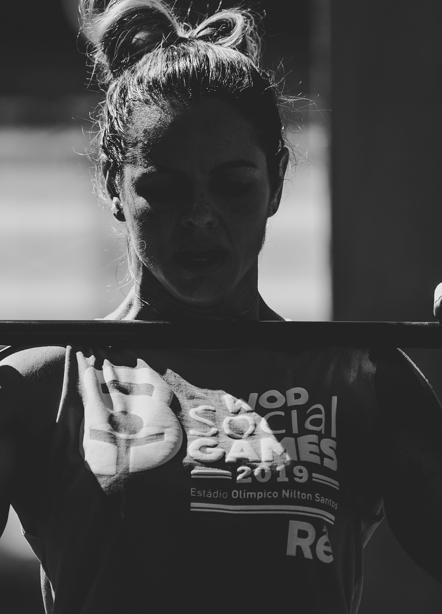 Wod Social Games Crossfit Uma mulher está levantando uma barra em uma foto em preto e branco.