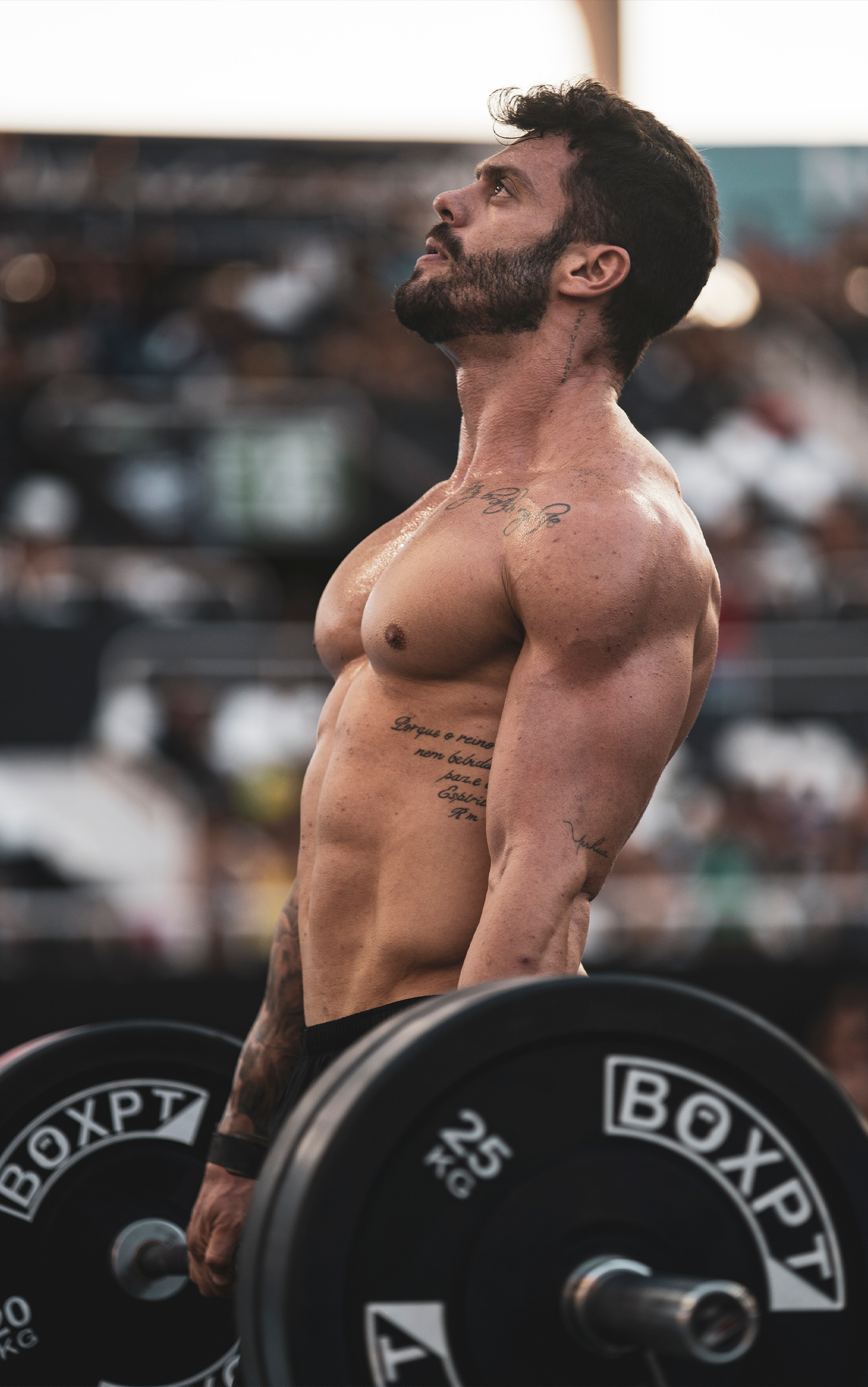 Wod Social Games Crossfit Um homem sem camisa está levantando uma barra em uma academia.