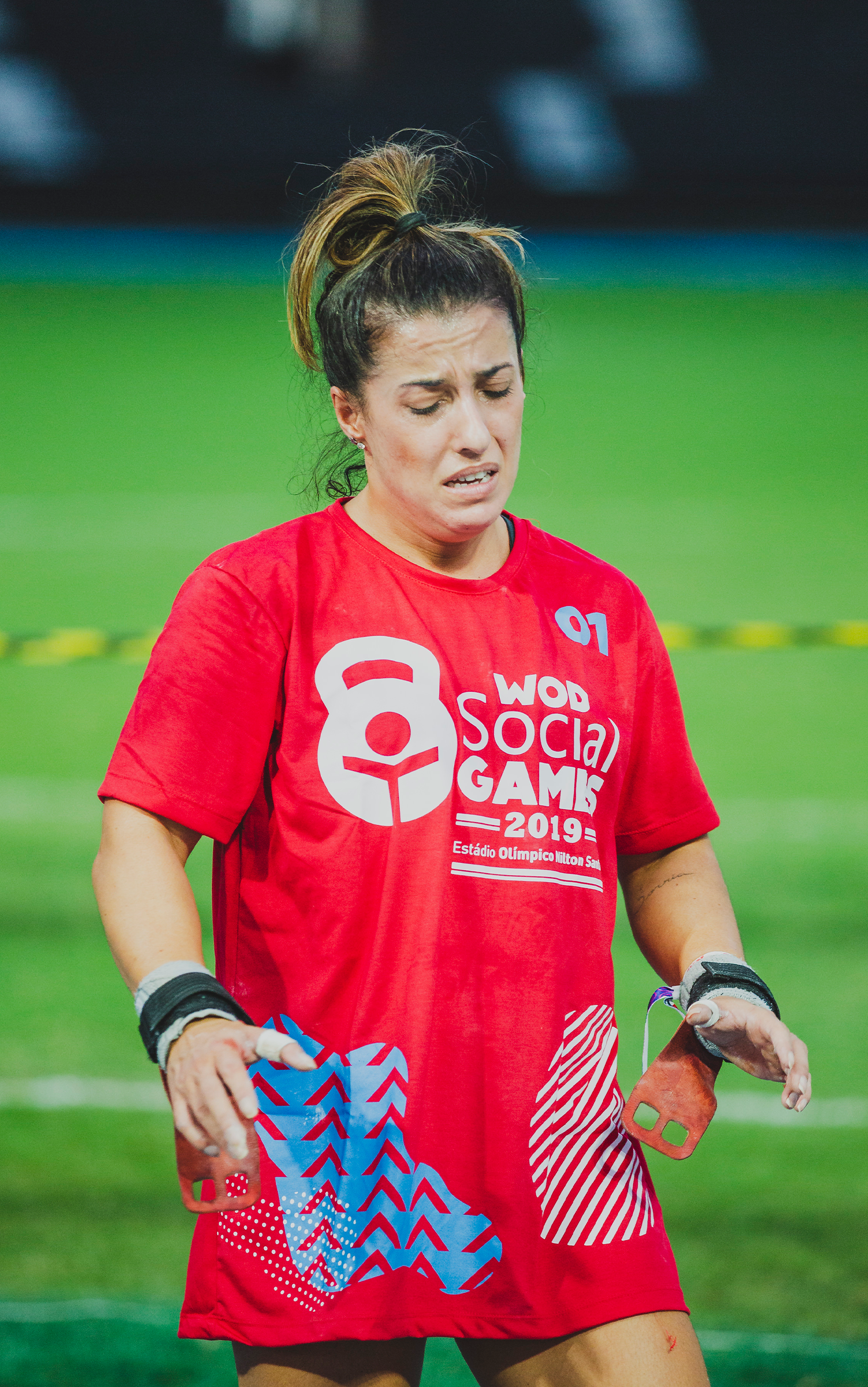 Uma mulher de camisa vermelha está em um campo de futebol.