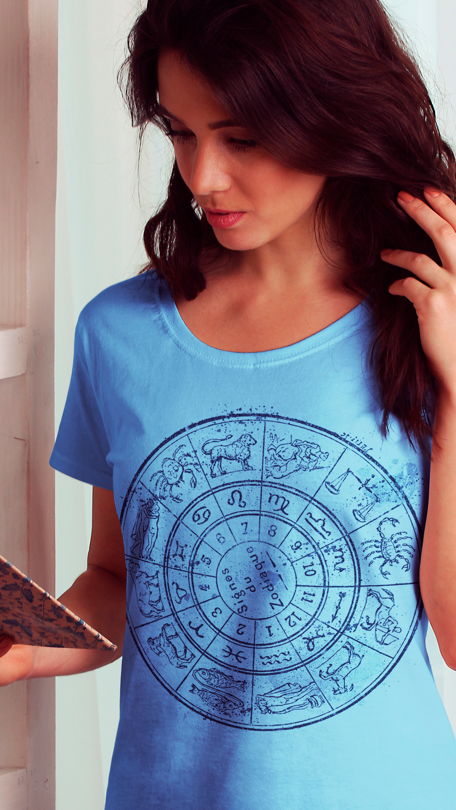 Uma mulher vestindo uma camisa azul com um signo do zodíaco