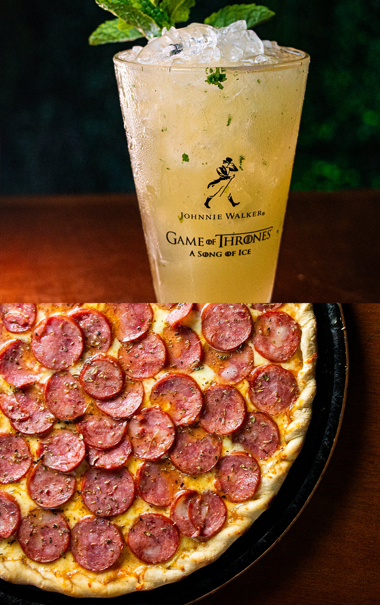 Uma pizza com salsicha e uma bebida em uma mesa.