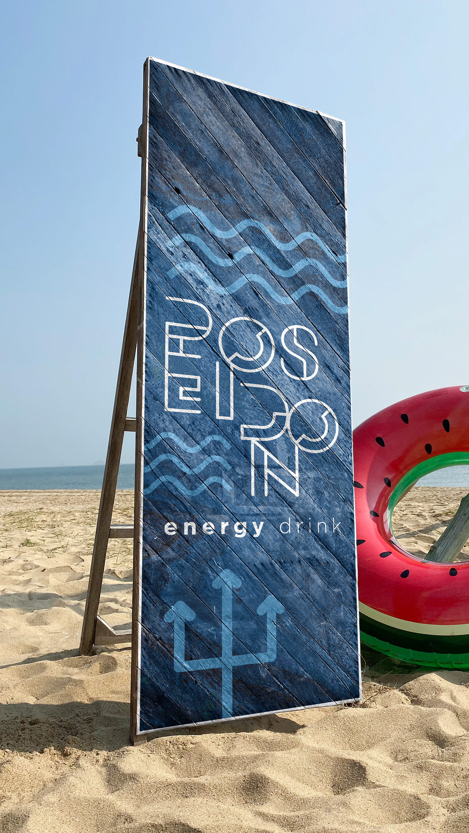 Poseidon Energy Drink A large sign is sitting on top of a sandy beach next to a watermelon float.